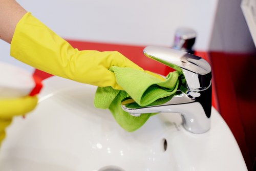 Cleaner placing a warning sign on a wet floor during routine cleaning